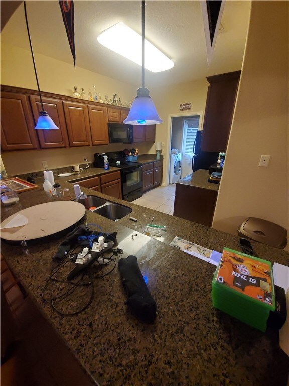 Kitchen with black appliances, washer / clothes dr