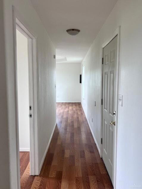 Hallway featuring wood finished floors and baseboards