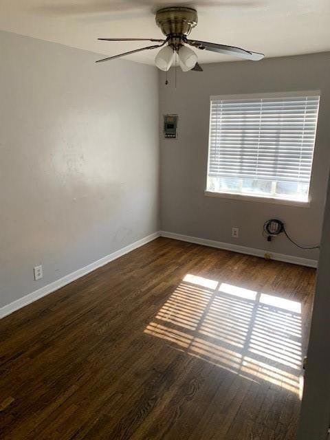 Spare room featuring baseboards, wood finished flo