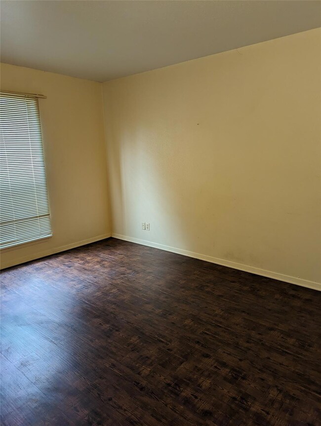 Unfurnished room with dark wood-type flooring