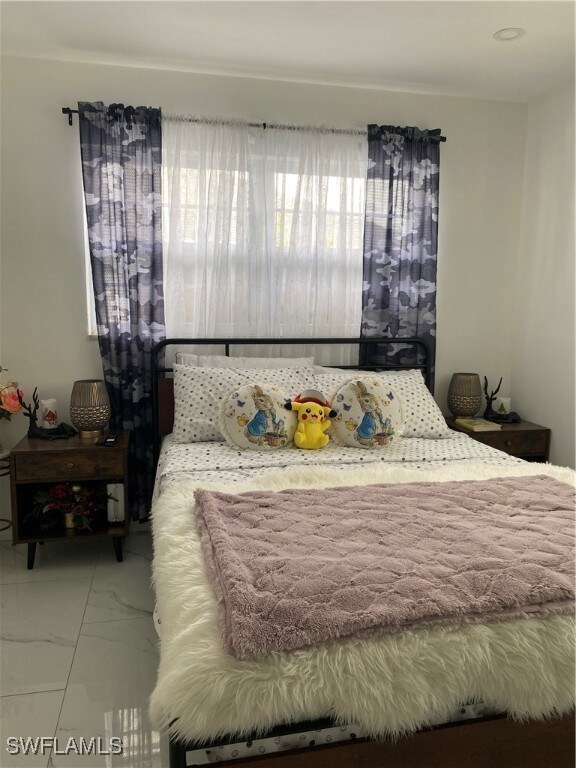 Bedroom featuring marble look tile flooring