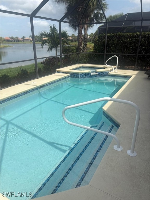 View of swimming pool with a sunroom, a pool with connected hot tub, glass enclosure, and a patio area