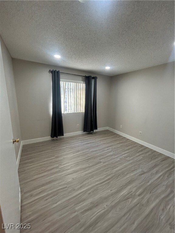Empty room with recessed lighting, wood finished f