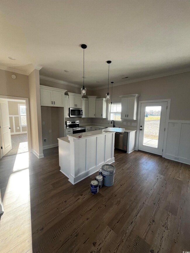 Kitchen with a kitchen island, white cabinetry, da