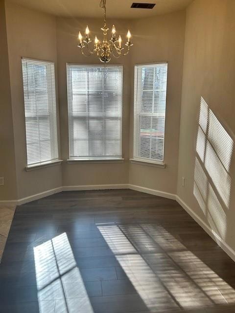 Unfurnished dining area featuring a chandelier, pl