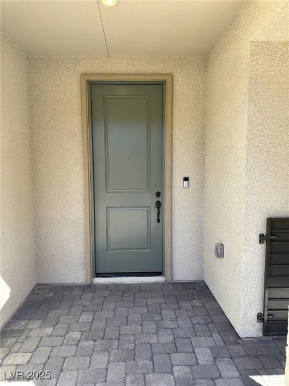 Entrance to property featuring stucco siding