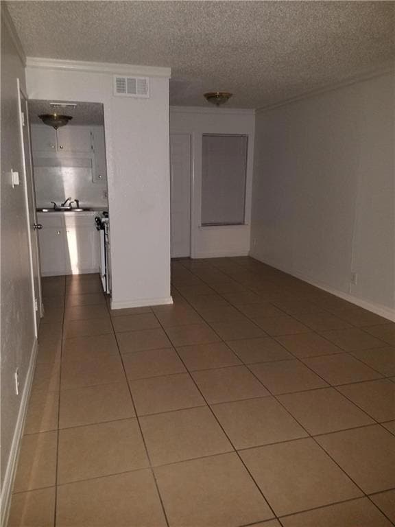 Spare room with a textured ceiling, crown molding