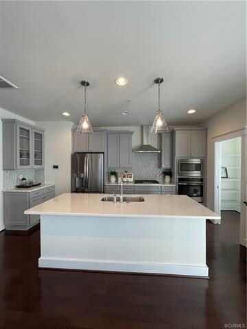 Gourmet kitchen with GE Profile wall oven, countertop range, quartz countertops, and expanded walk-in pantry