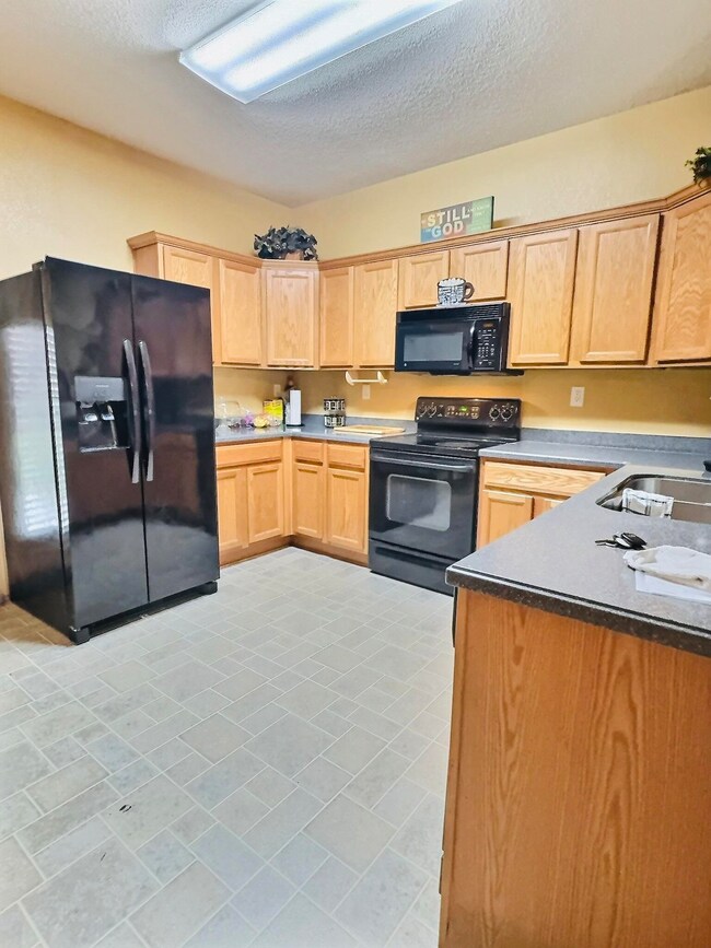 Kitchen featuring black appliances, sink, and ligh
