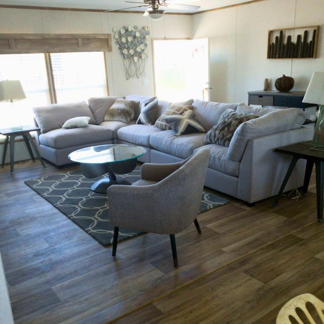 Living area with ceiling fan and wood finished fl