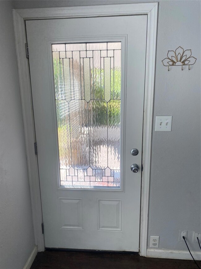 Doorway with a wealth of natural light and dark hardwood / wood-style floors