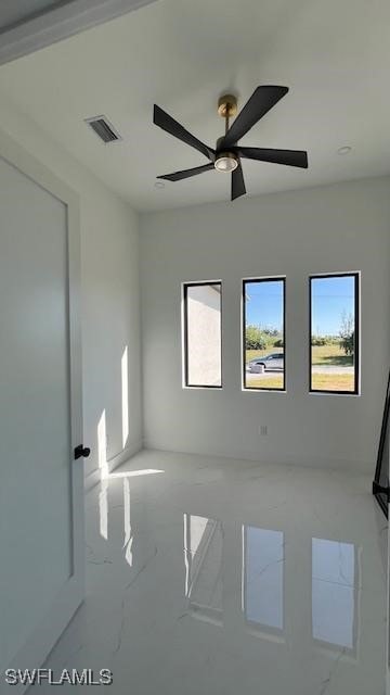 Empty room with a ceiling fan and marble finish fl