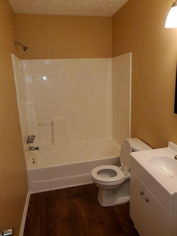 Bathroom with wood finished floors, vanity, and shower / washtub combination