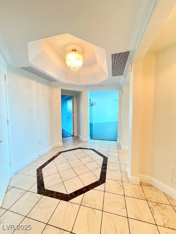 Spare room with a raised ceiling, baseboards, and