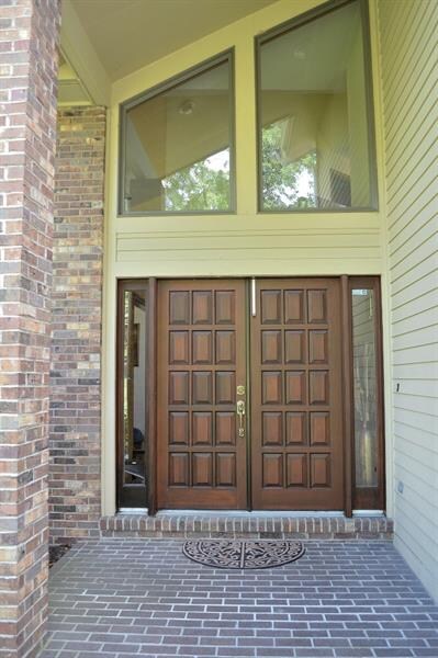 The brick walkway leads to the grand double door, 