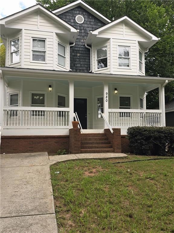 View of front facade with a porch and a front lawn