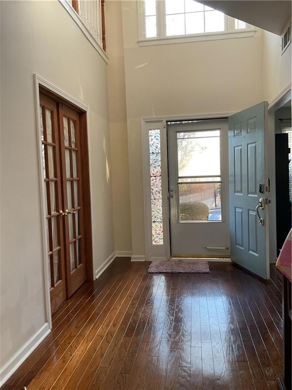 Entrance foyer with a high ceiling and dark hardwo