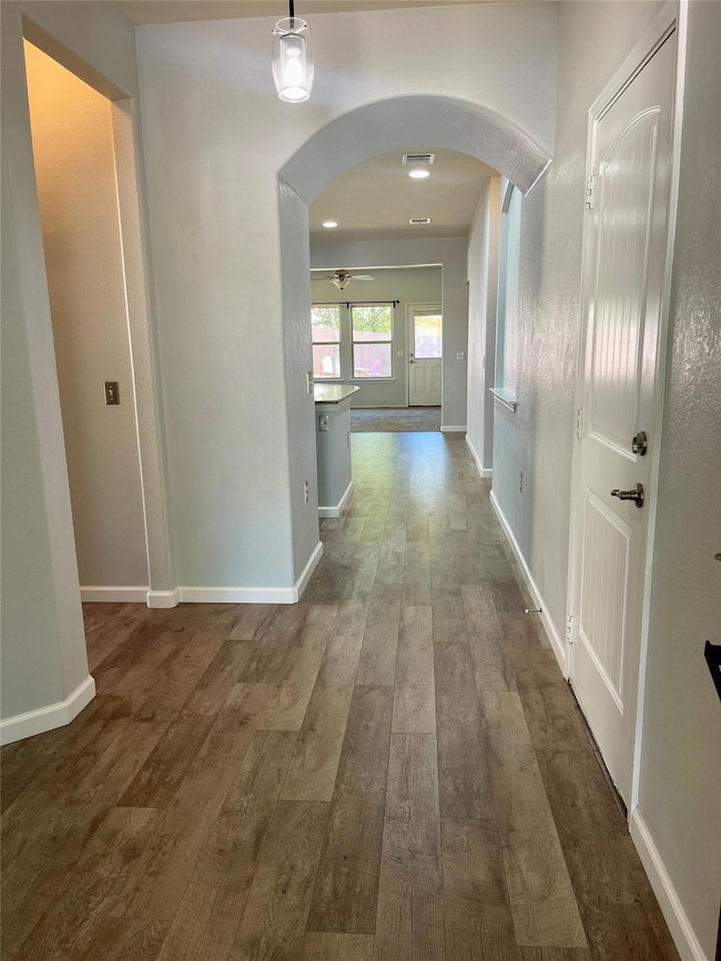 Hallway with arched walkways and dark wood-style 