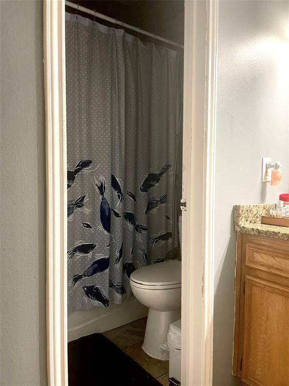 Full bath with toilet, vanity, and a shower with 