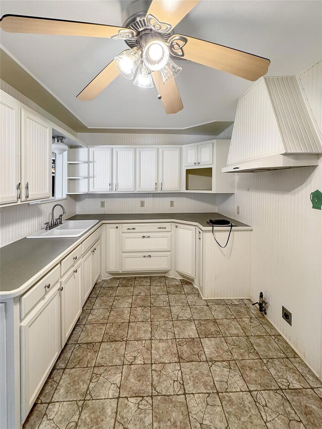 Kitchen with ceiling fan, tasteful backsplash, lig