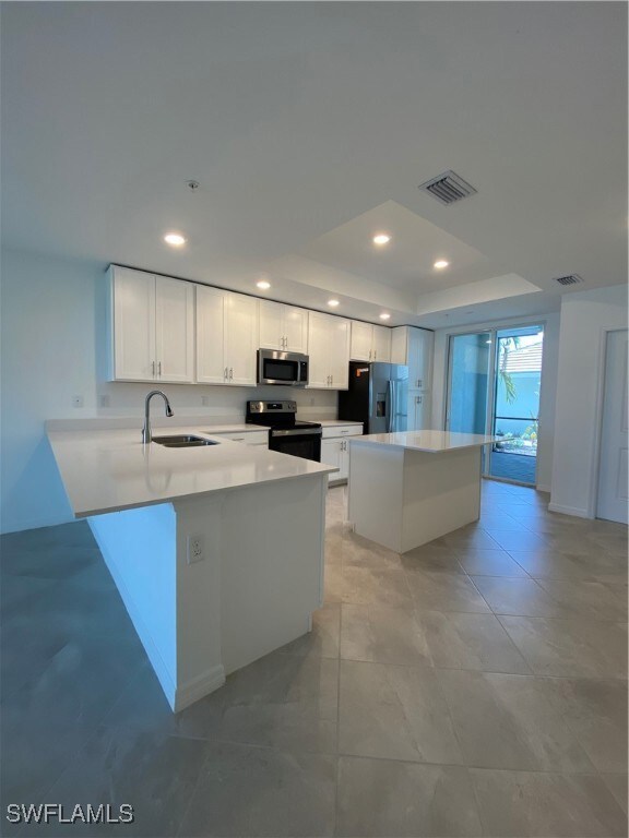 Kitchen with stainless steel stove, white cabinets