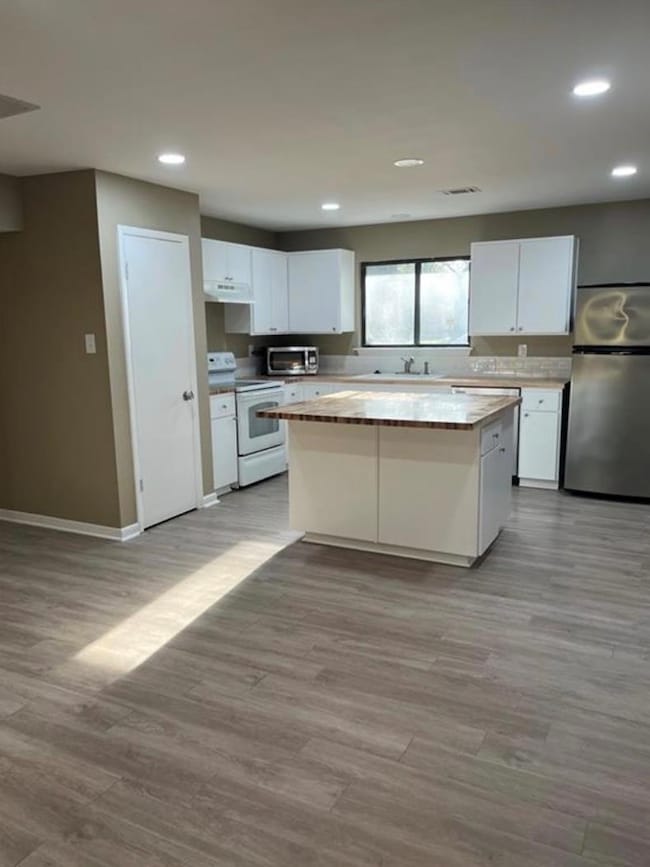 Kitchen with a center island, white cabinetry, fr