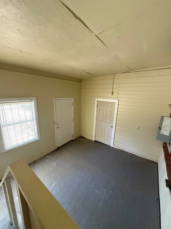 Foyer entrance with a textured ceiling and concrete flooring