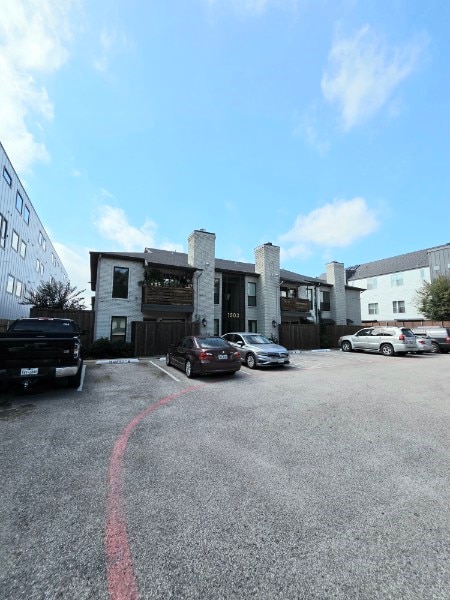 View of building exterior featuring uncovered parking