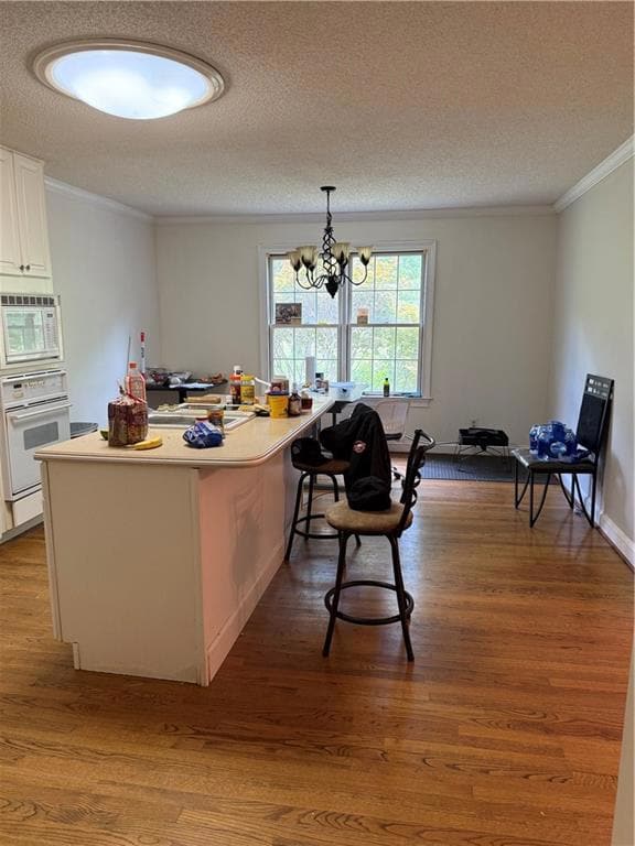 Kitchen with a sink, white cabinets, wood finished