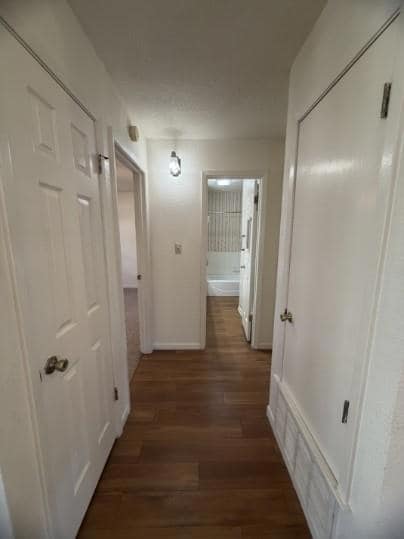 Hall with dark wood finished floors and baseboards