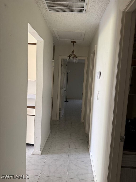 Corridor featuring light marble finish flooring an