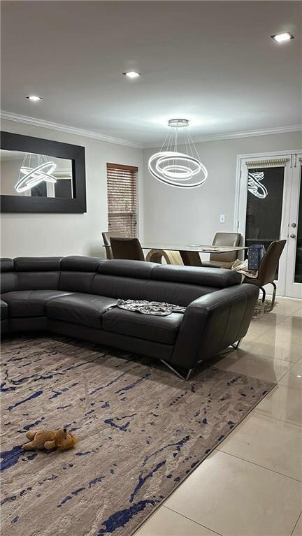 Living room featuring a chandelier, ornamental molding, and recessed lighting