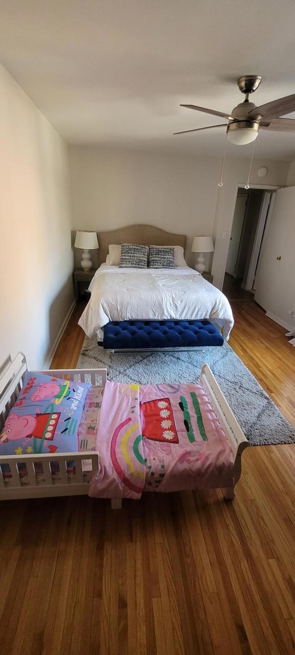 Bedroom featuring baseboards, a ceiling fan, and wood finished floors