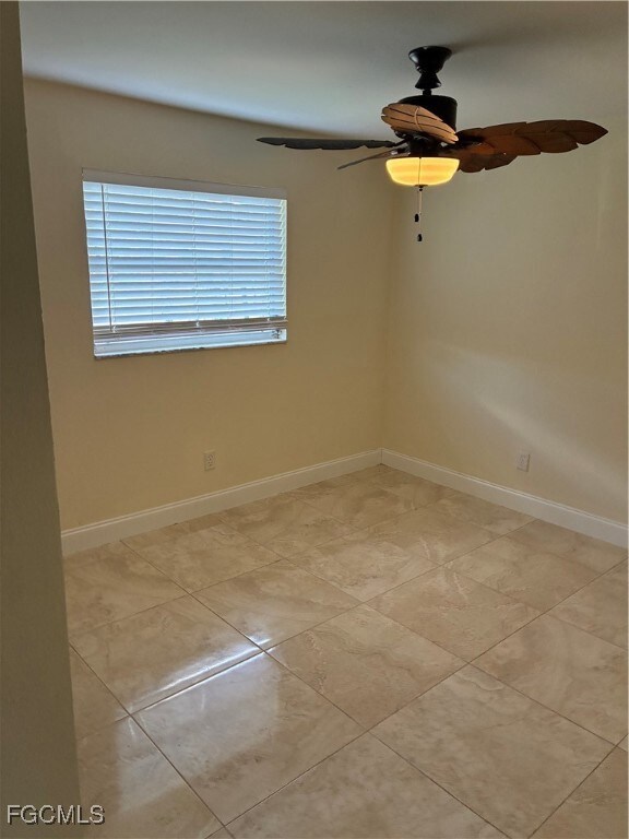 Spare room with ceiling fan and light tile patterned flooring