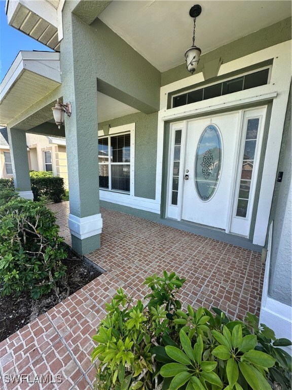 Property entrance with stucco siding and a porch