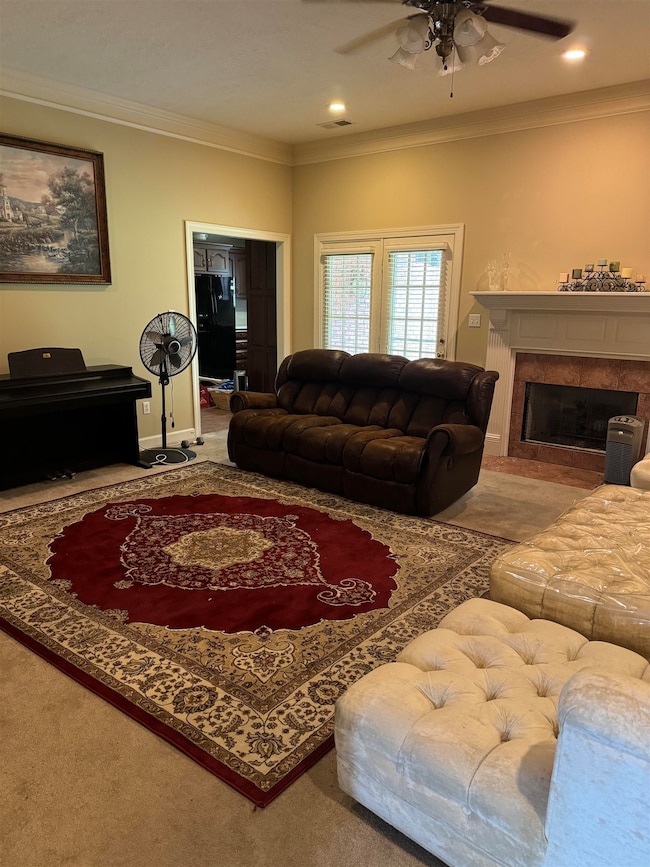 Living room with ornamental molding, a tiled firep