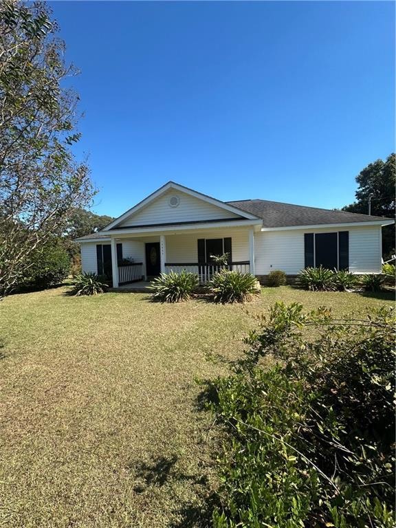View of front of house with covered porch and a front yard