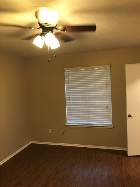 Spare room with dark wood finished floors, a ceili