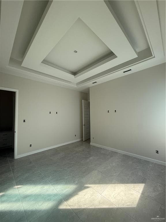Spare room with a tray ceiling and baseboards