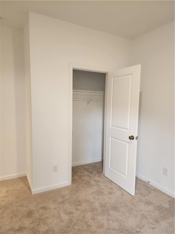 Unfurnished bedroom featuring baseboards, carpet f