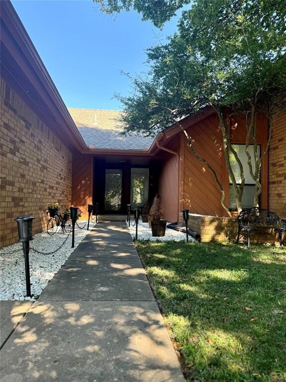 Doorway to property featuring a lawn