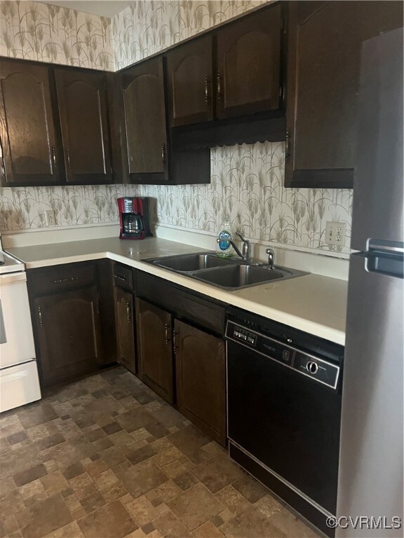 Kitchen with sink, dark brown cabinetry, fridge, a