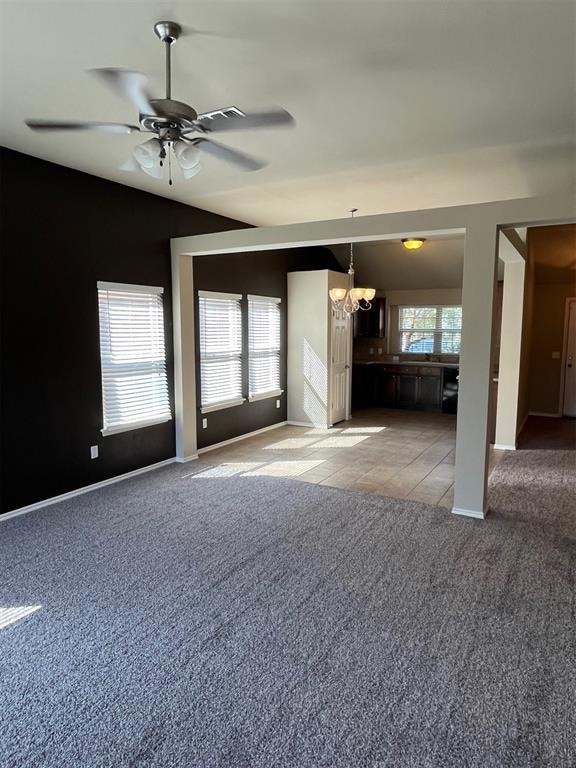 Unfurnished living room featuring ceiling fan with