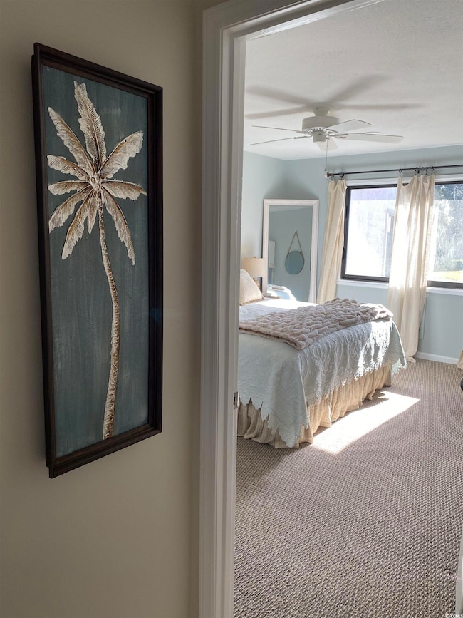 Carpeted bedroom featuring ceiling fan