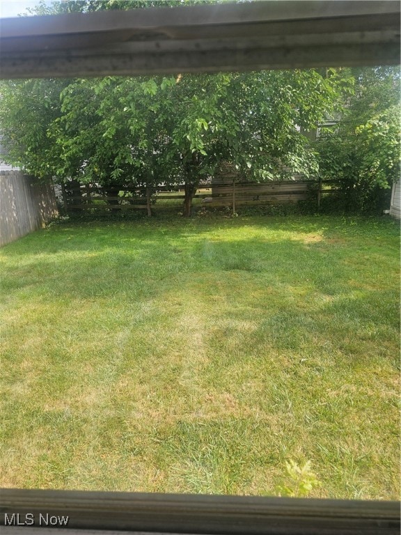 Fenced backyard featuring a detached carport