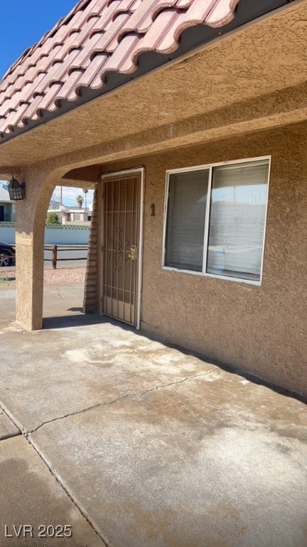 View of exterior entry featuring a patio, stucco s