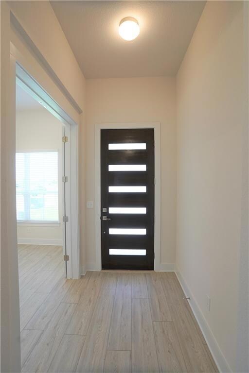 Entrance foyer with wood finished floors and base