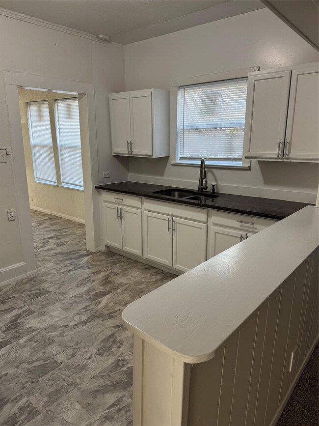 Kitchen featuring white cabinets and sink
