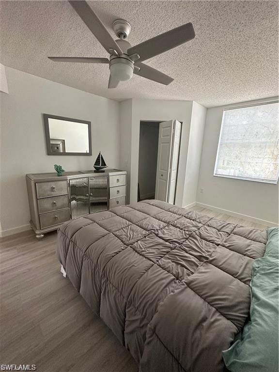 Bedroom featuring wood finished floors, a textured ceiling, and a ceiling fan