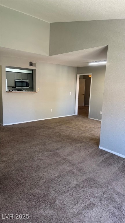 Carpeted empty room featuring lofted ceiling and b